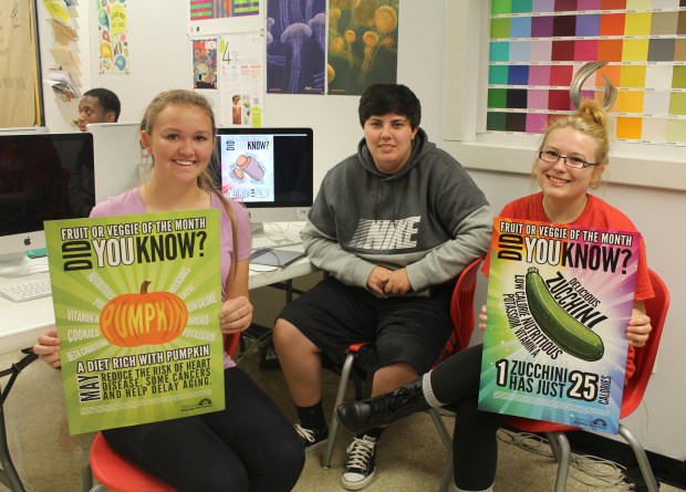 [Left to Right] PRP Seniors Kelaiah Clark, Danielle Craft, and Taylor Gray display their designs created for the JCPS Nutrition Services Fruit & Veggie of the Month Campaign.